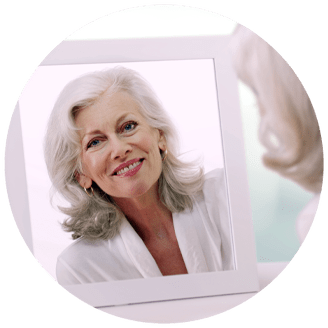 dental-implant patient looking in mirror smiling